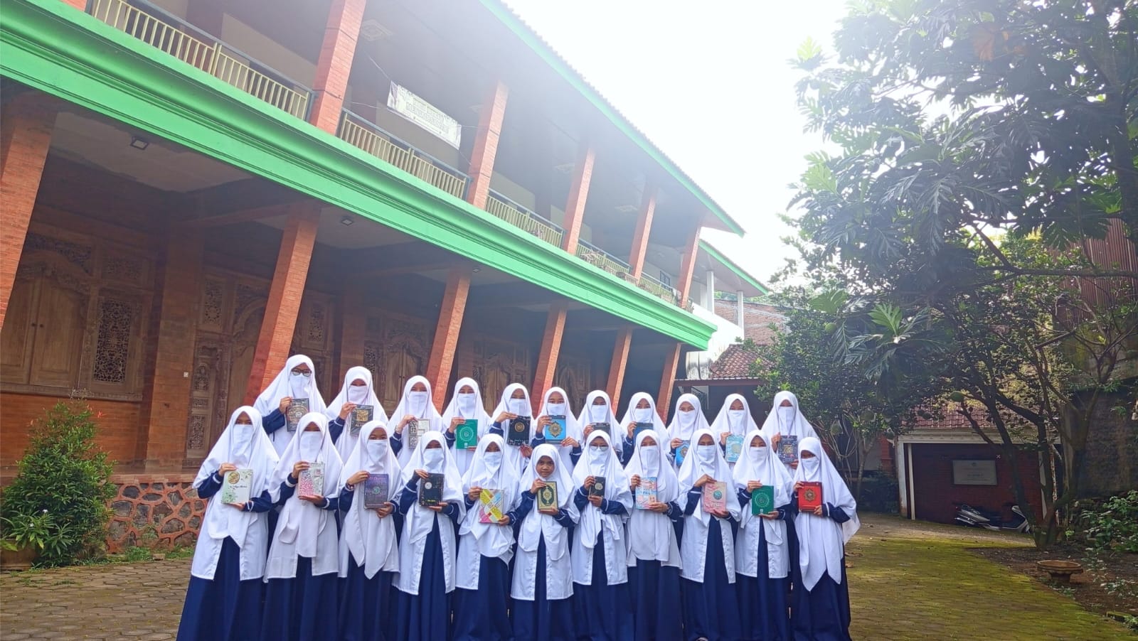 Santriwati Al Maka membawa mushaf di halaman unit putri