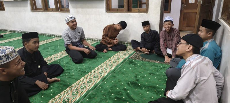 Ustadz duduk bersama santri usrohnya di masjid
